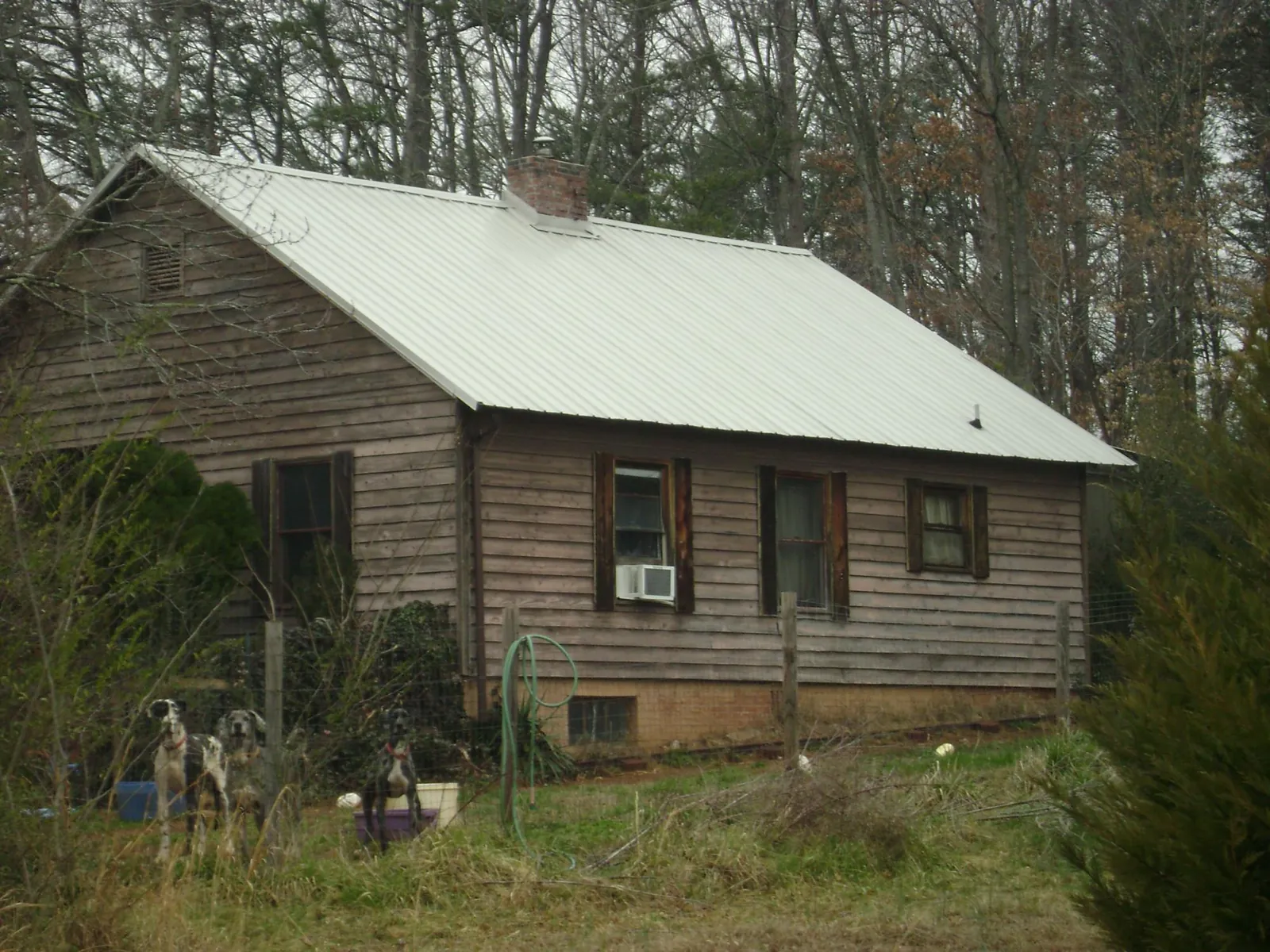 White metal roof on an old wood sided farmhouse, from a Asphalt Shingle Roof Repair job in Cartersville